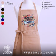 Фартух мамина кухня, бежевого кольору, зображений з фронтального ракурсу, на фоні світлого однотонного фону, принт містить текст "Мамина кухня - закон" та ілюстрації кухонних предметів.