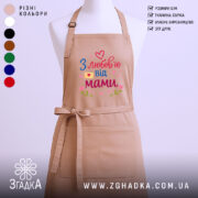 Фартух з любов’ю мами, бежевого кольору, зображений на манекені, фон світлий, принт з написом 'З любов’ю від мами' у яскравих кольорах з сердечками та квітами.