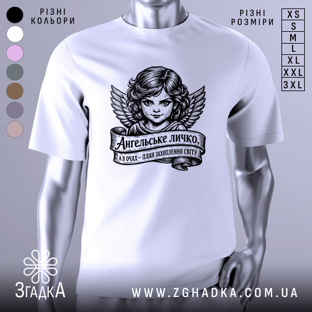 Футболка ангельське личко, біла, зображена на манекені, фон світло-сірий, принт з зображенням ангела з крилами та написом на стрічці.