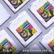 Футболка ану усміхнися — кілька складених футболок, композиція на столі.