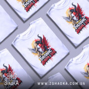 Футболка баланс добра зла, біла, з фронтального ракурсу, на манекені, фон світло-сірий, принт з зображенням дівчини з ангельськими і дияволячими елементами, яскраві кольори, червоний, чорний, жовтий, деталі з краплями фарби.