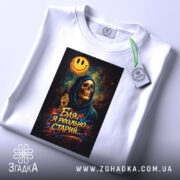 Футболка бля я старий, біла, зображена зверху, фон світлий, принт з черепом у капюшоні, що тримає жовту усміхнену кульку, на футболці є етикетка з зеленим шнурком.