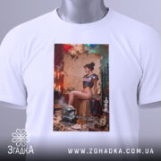 Футболка бунтарка стімпанк, біла, зображення моделі на футболці з етикеткою, ракурс зверху, фон з червоними і зеленими елементами, деталі принта включають шолом і годинник на підлозі.