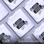 Футболка чемна дівчинка, білого кольору, зображена на манекені з правого ракурсу, фон нейтральний, принт містить текст і малюнки ангела та дівчинки з чортом.