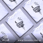 Футболка дівчата це сила, білого кольору, зображена з правого ракурсу на манекені, фон світлий, принт чорного кольору з написом 'Дівчата це сила' та силуетом дівчини з піднятою рукою.