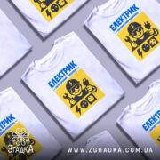 Футболка для електрика, білого кольору, зображена з фронтального ракурсу на манекені, фон нейтральний, принт містить жовті та сині елементи з малюнком електрика, який тримає інструменти та електричні розетки.