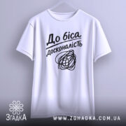 Футболка до біса досконалість, біла, підвішена на вішалці, фон світло-сірий, принт чорний з написом 'До біса досконалість' і абстрактним малюнком.