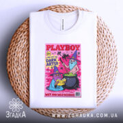 Футболка дикі чарівники, біла, зображена зверху на плетеному кошику, фон світлий, принт з двома чарівниками, один читає книгу, інший варить зілля, яскраві кольори на рожевому фоні.