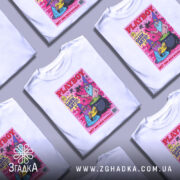 Футболка дикі чарівники, біла, зображена на манекені з правого боку, фон нейтральний, принт з двома чарівниками в шапках, один читає книгу, інший варить зілля в казані, яскраві кольори принта на рожевому фоні.