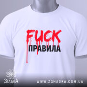 Футболка fuck правила, біла, складена на поверхні, фон світло-сірий, принт червоний з краплями фарби та чорний текст, з етикеткою на комірці.