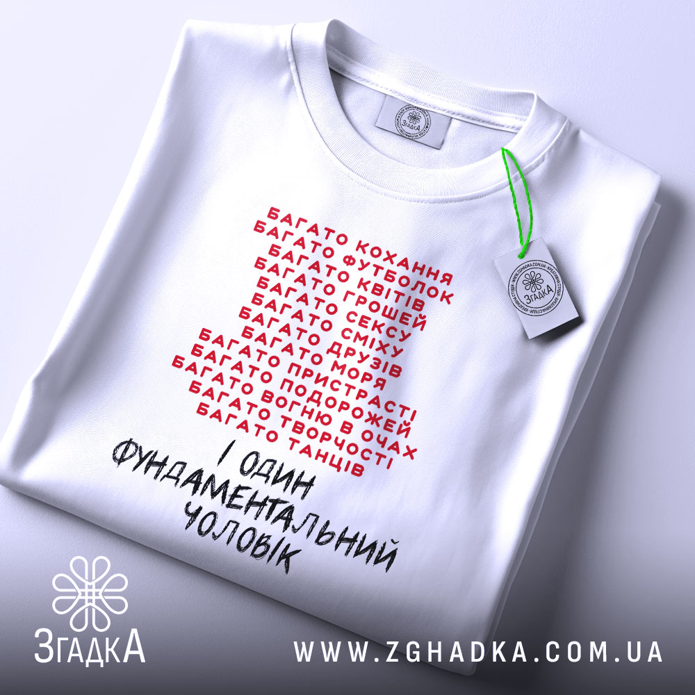 Футболка фундаментальний чоловік, біла, зображена зверху, фон світло-сірий, принт червоними і чорними літерами, текстовий дизайн з фразами про різні захоплення, на комірці видно етикетку.
