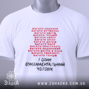Футболка фундаментальний чоловік, біла, зображена зверху, фон світло-сірий, принт червоними і чорними літерами, текстовий дизайн з фразами про різні захоплення, на комірці видно етикетку.