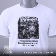 Футболка гетьмани змінюються. Біла футболка з чорним принтом, зображення гетьмана на фоні замку, ракурс зверху, видно етикетку з зеленим шнурком, принт чітко виділяється на фоні.