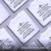 Футболка графіки відключень, білого кольору, зображена на манекені з правого боку, фон світло-сірий, принт чорного кольору з малюнком електричної опори та відкритої книги, текст українською мовою.
