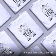 Футболка я обираю тебе. Біла футболка з коротким рукавом, зображена в анфас на манекені. На фоні світло-сірий градієнт. Принт містить малюнок НЛО, гори та напис 'Я обираю ТЕБЕ' великими чорними літерами.