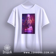 Футболка я вже стара. Біла футболка, підвішена на вішалці, з принтом скелета у рушнику, що тримає телефон. Фон світлий, принт яскравий.