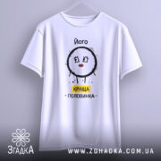 Футболка його краща половинка, білого кольору, підвішена на вішалці, фон світлий, принт з малюнком круглого персонажа з червоними губами та написом 'КРАЩА ПОЛОВИНКА' жовтого кольору, видно деталі швів.