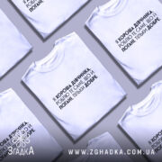 Футболка хороша дівчинка. Біла футболка на манекені, з коротким рукавом, на світлому фоні. Принт чорного кольору з текстом, що займає центральну частину футболки.