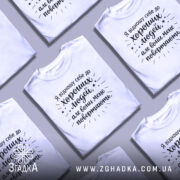 Футболка хороші люди, біла, зображена на манекені, фон світло-сірий, принт чорного кольору з текстом та зірочками.