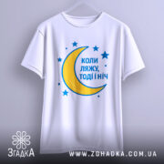 Футболка коли ляжу, біла, підвішена на вішалці, фон світло-сірий, принт з жовтою місяцем та синіми зірками, текст синій.
