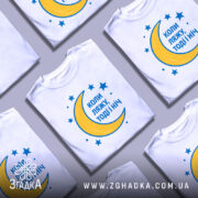 Футболка коли ляжу, біла, зображена на манекені, фон світло-сірий, принт з жовтою місяцем та синіми зірками, текст синій.