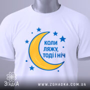 Футболка коли ляжу, біла, складена на поверхні, фон світло-сірий, принт з жовтою місяцем та синіми зірками, текст синій, з етикеткою.