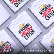 Футболка королева його серця, біла, зображена на манекені, фон світло-сірий, принт з короною, червоним написом і сердечками.