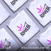 Футболка королева білого кольору, зображена на манекені з правого боку, фон світло-сірий, принт з фіолетовою короною та чорним написом 'КОРОЛЕВА' з крапельками.