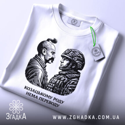 Футболка козацькому роду нема переводу. Біла футболка з округлим вирізом, зображення двох чоловіків на грудях, один у козацькому одязі, інший у військовій формі, принт чорного кольору, на футболці зелений ярлик, фон світлий.