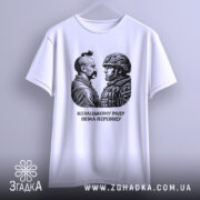 Футболка козацькому роду нема переводу. Біла футболка з коротким рукавом, зображення двох чоловіків, один у козацькому одязі, інший у військовій формі, принт чорного кольору, фон світлий, футболка підвішена на вішалці.