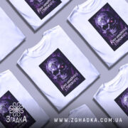 Футболка краса з порожнечі, біла, зображена з фронтального ракурсу на манекені, фон нейтральний, принт з черепом у фіолетових тонах з червоним оком та написом.