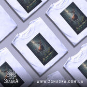 Футболка ліс знає ким я є, біла, зображена з фронтального ракурсу, на фоні нейтрального сірого кольору, принт з оленями в лісі з текстом на українській мові.