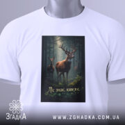 Футболка ліс знає ким я є, біла, зображена з верхнього ракурсу, на фоні світлого кольору, принт з оленями в лісі, з етикеткою на зеленому шнурку.