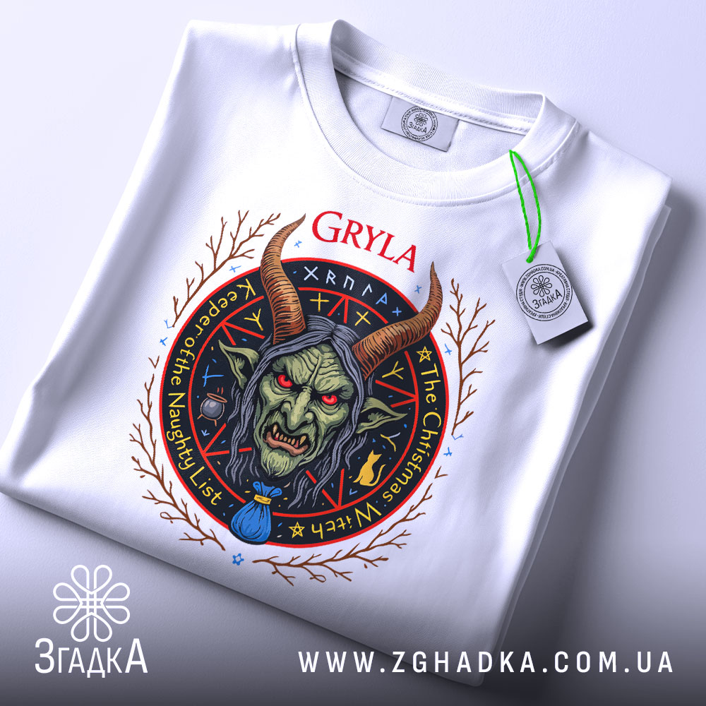 Футболка міфічна Ґрила білого кольору, зображена з верхнього ракурсу, на ній видно етикетку з зеленим шнурком, фон світло-сірий, принт з обличчям міфічної істоти з рогами та червоними очима, оточений декоративними елементами.