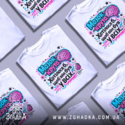 Футболка мозок це круто. Біла футболка з яскравим принтом на грудях, зображення мозку та тексту в кольорах рожевий, блакитний і чорний. Фон нейтральний, манекен зображений спереду.