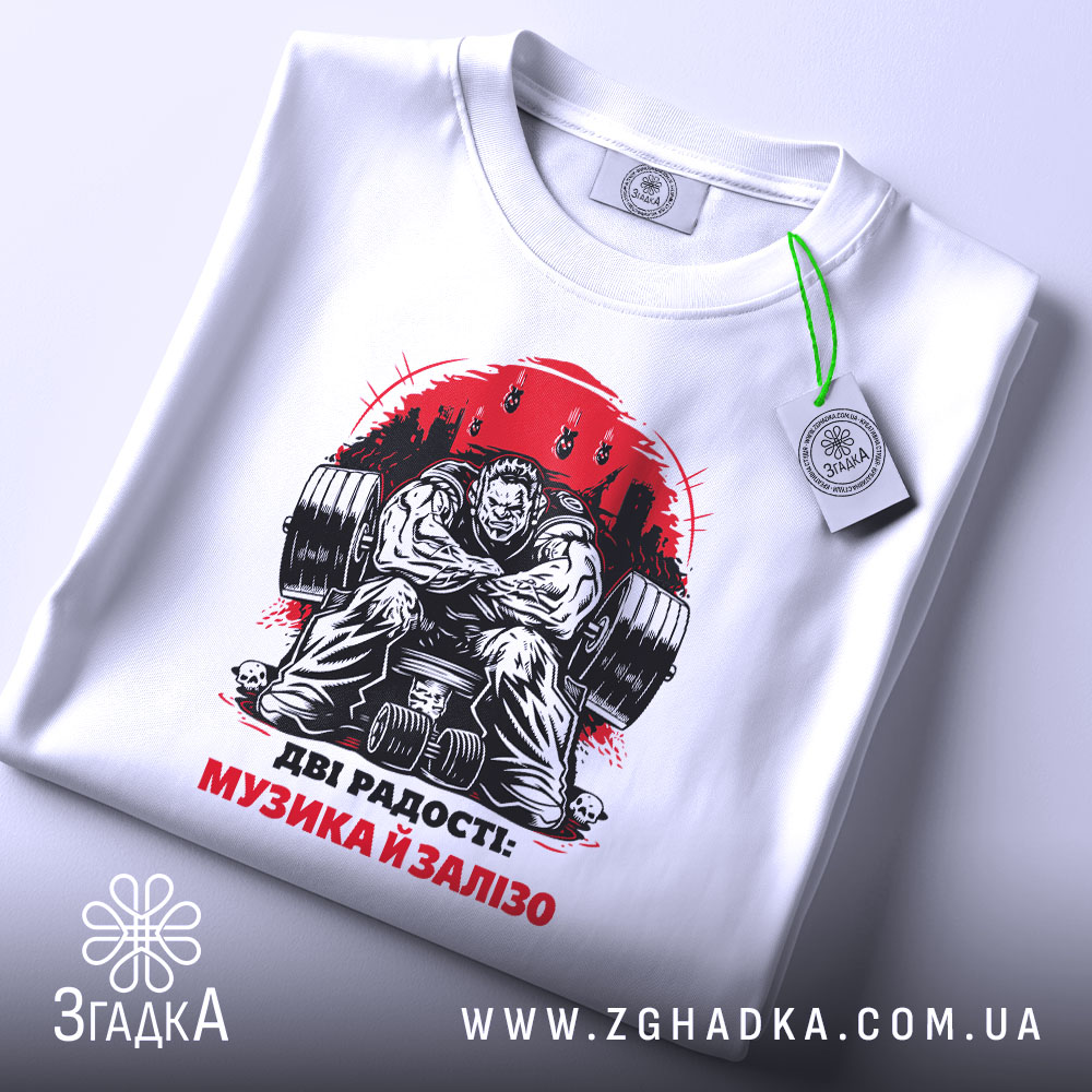 Футболка музика і залізо: біла футболка з принтом, зображення чоловіка з важкими гирями, ракурс зверху, на футболці є етикетка з зеленим шнурком, фон світлий.
