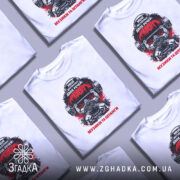 Футболка музика та штанги, біла, зображена на манекені, фон світло-сірий, принт з чорним і червоним кольорами, зображення атлета з штангою та написом 'Мені достатньо двох речей: музики та штанги'.