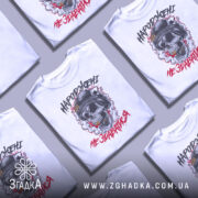 Футболка народжені не здаватися, білого кольору, зображена з фронтального ракурсу на манекені, фон світло-сірий, принт з черепом у військовій касці, оточений димом та червоними акцентами.