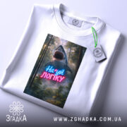 Футболка на*уй логіку, біла, складена на столі, фон світлий, принт з акулами та написом у неонових кольорах, з етикеткою.