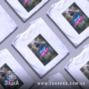 Футболка на*уй логіку, біла, зображена на манекені, фон нейтральний, принт з акулами та написом у неонових кольорах.