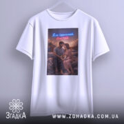 Футболка не ідеальний але твій. Біла футболка на манекені, з принтом пари, що сидить на ліжку, з м'яким освітленням.