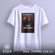 Футболка нема батога. Біла футболка з коротким рукавом, зображена з фронтального ракурсу на світло-сірому фоні. Принт з ведмедем, який тримає пряник, з текстом на українській мові.