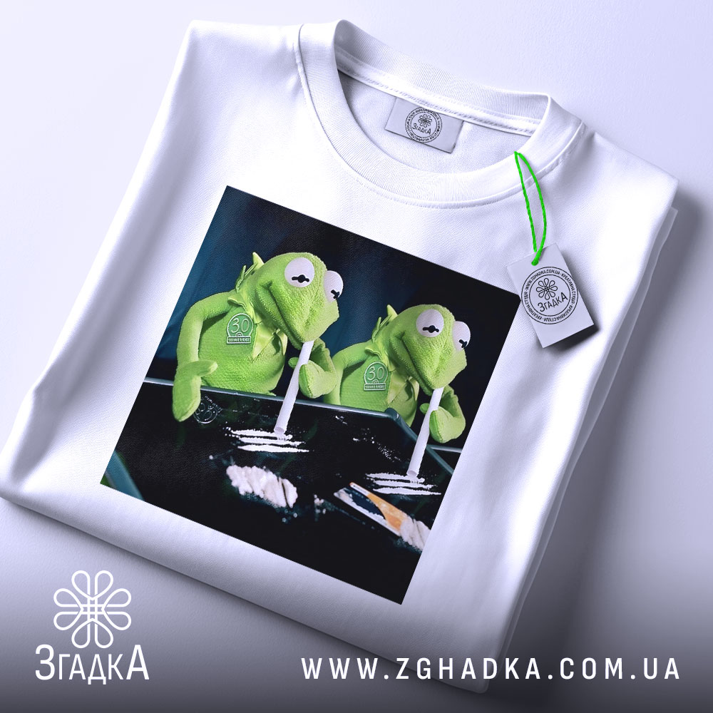 Футболка ніч без сну, біла, з верхнього ракурсу, складена, з етикеткою, на принті дві зелені ляльки, що тримають трубочки, фон чорний.
