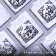 Футболка пес Патрон білого кольору, зображена з фронтального ракурсу на манекені, фон нейтральний, принт з чорно-білим зображенням собаки Патрона на фоні рослинності та будівлі.