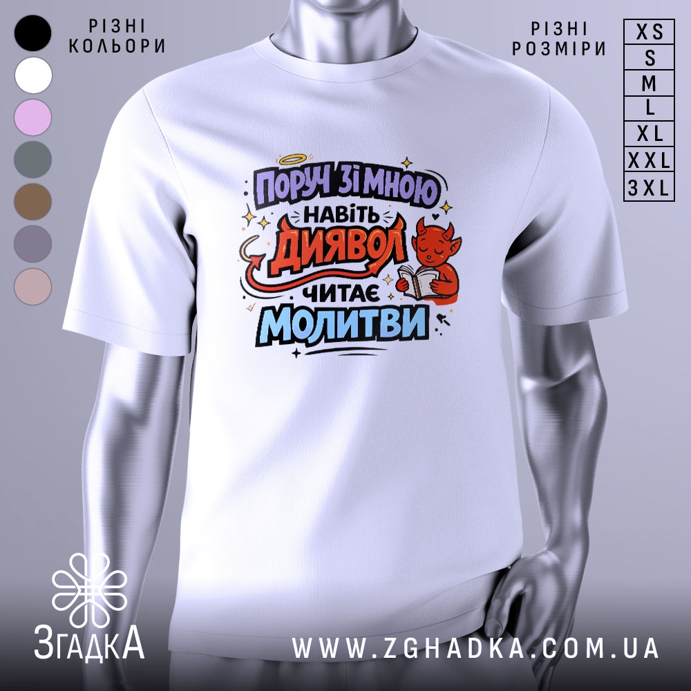 Футболка поруч зі мною, білого кольору, з принтом на грудях, зображує червоного диявола, який читає молитви, фон світло-сірий, ракурс з правого боку.