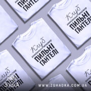 Футболка пильні гантелі, біла, зображена на манекені з правого ракурсу, фон світло-сірий, принт чорного кольору з текстом 'Клуб анонімних менеджерів' та 'Пильні гантелі'.