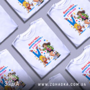 Футболка шалена подруга завжди білого кольору, зображена з близького ракурсу, на фоні світло-сірого кольору. Принт містить двох дівчат: одна стоїть на руках, інша тримає келих, обидві веселі, оточені зірочками та пляшками.