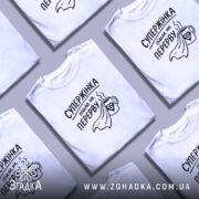 Футболка супержінка на перерві — кілька складених футболок, композиція на столі.