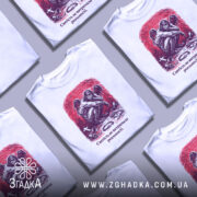 Футболка святість і реальність. Біла футболка з коротким рукавом, зображена з фронтального ракурсу на манекені. На футболці принт з зображенням ангела, що сидить на землі, оточеного символами, такими як хрест і кайдани, на червоному фоні. Текст під принтом: 'Святість не витримала реальності.'