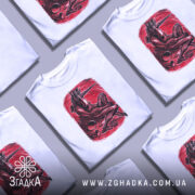 Футболка темний сюрреалізм, біла, зображена на манекені, фон світло-сірий, принт червоного кольору з зображенням істоти з рогами, що сидить в позі, з чорними деталями.